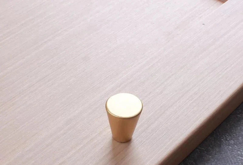 Bouton de meuble en or brossé sur fond blanc