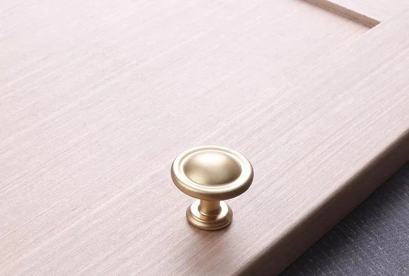 Bouton de meuble en aluminium or brossé sur fond blanc