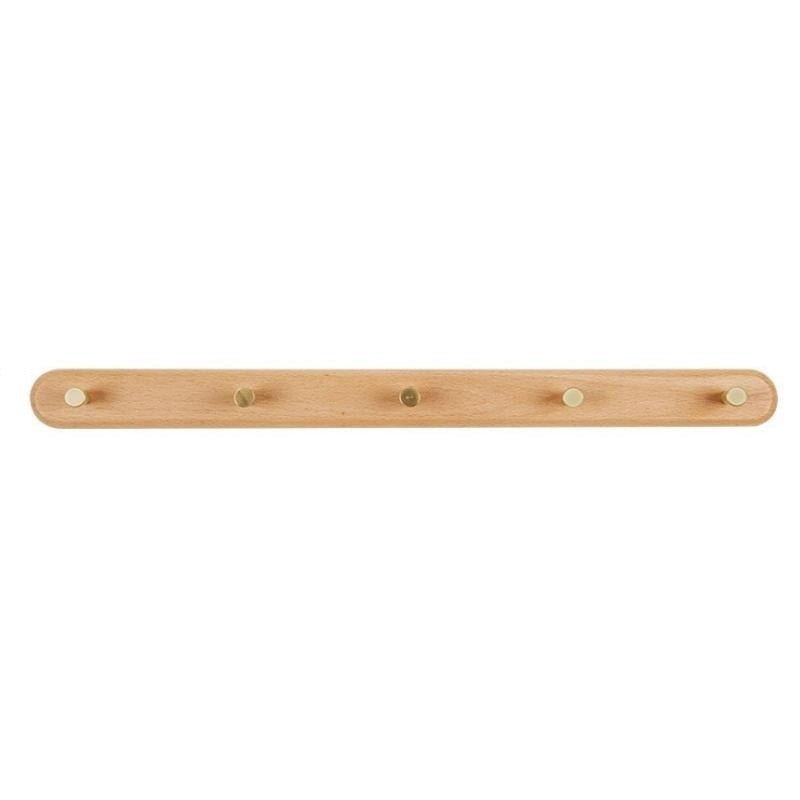 Porte-manteau en bois et laiton dans une salle de bain