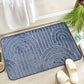 Tapis de bain en polyester doux, posé sur un sol de salle de bain