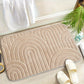Tapis de bain géométrique sur sol carrelé, vue de dessus