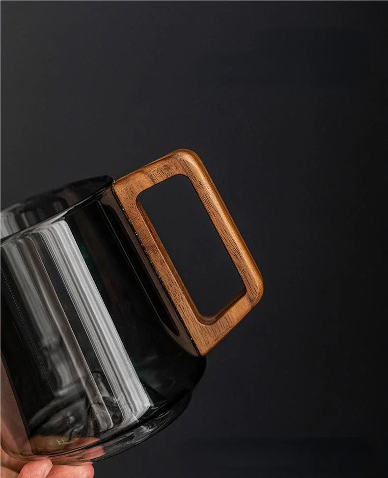 Tasse en verre avec poignée en bois sur fond blanc