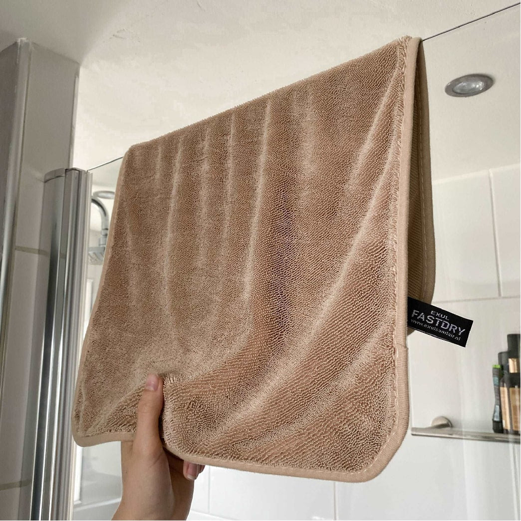 Serviette beige en microfibre posée sur une surface lisse