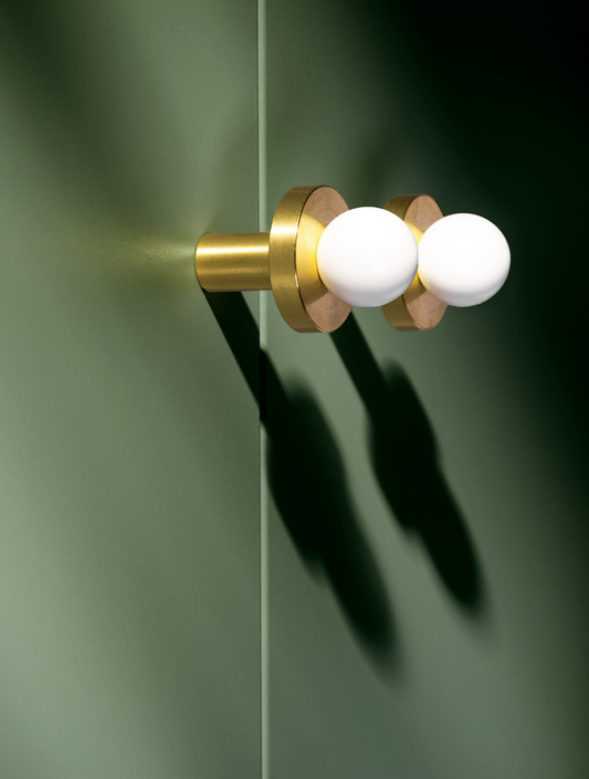 Bouton de meuble blanc et or sur fond neutre