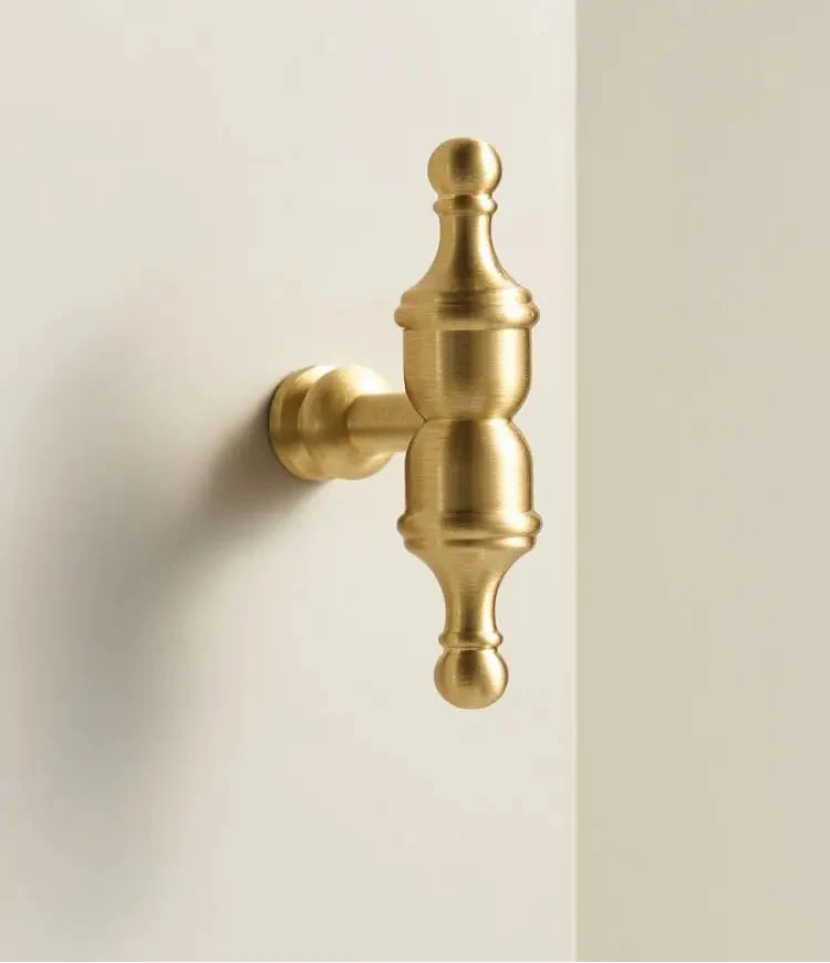 Gros plan sur un bouton de meuble doré avec texture brossée