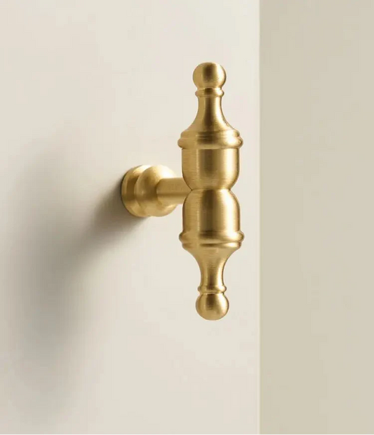 Gros plan sur un bouton de meuble doré avec texture brossée