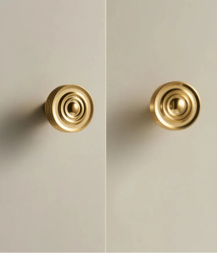 Bouton de meuble en laiton or brossé sur fond blanc