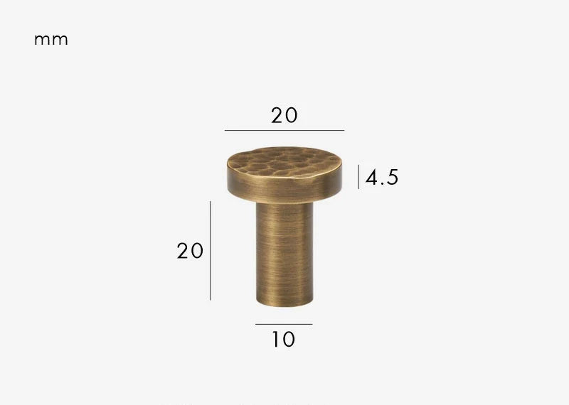 Détail de la texture martelée d'un bouton de meuble bronze