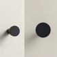 Bouton de meuble noir en laiton sur fond blanc