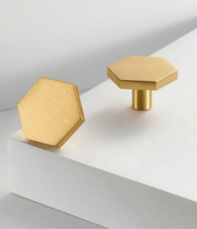 Bouton hexagonal en laiton sur fond blanc