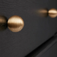 Gros plan sur la texture nervurée du bouton de meuble doré
