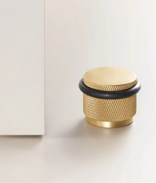 Gros plan sur la texture or brossé du butoir de porte