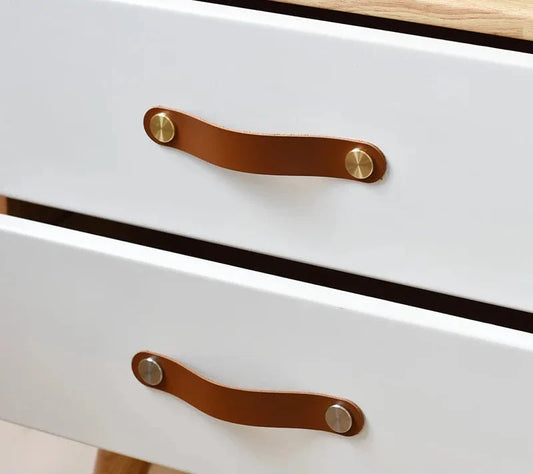 Poignée de meuble en cuir marron, détails de couture visibles