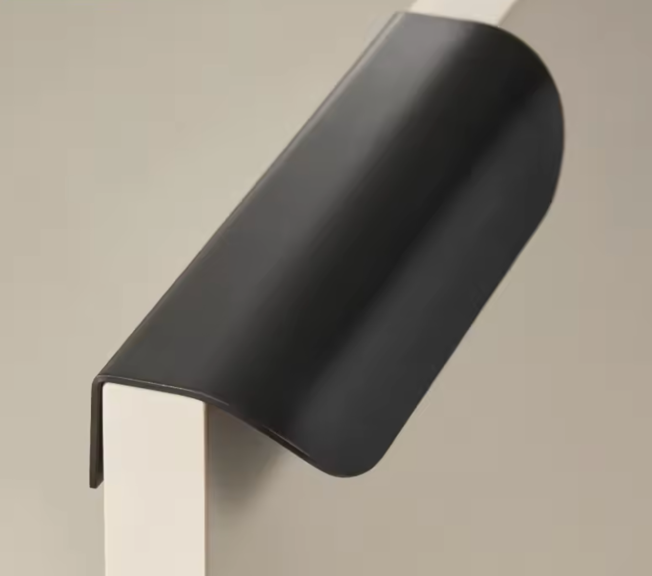 Poignée de meuble noire en laiton sur fond blanc