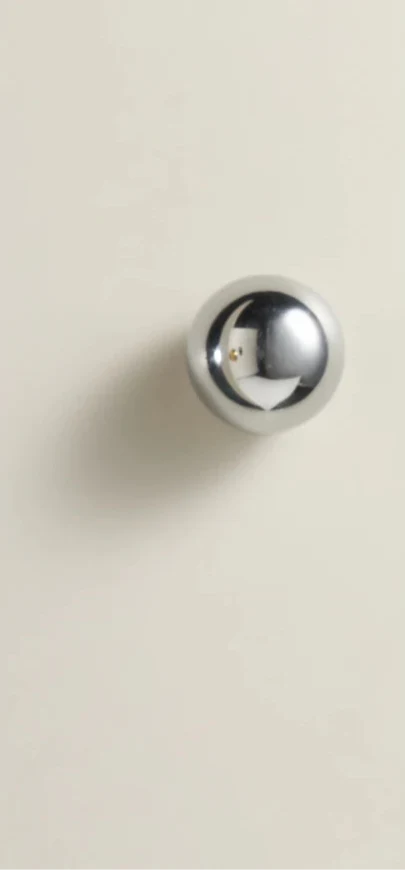 Poignée de meuble en chrome vue de face sur fond blanc
