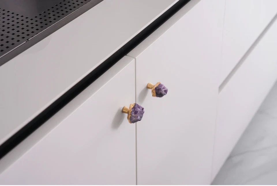 Poignée en laiton avec pierre violette sur fond blanc