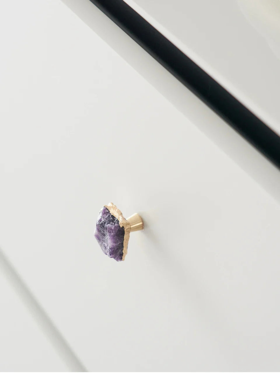 Vue rapprochée d'une poignée en laiton et pierre violette