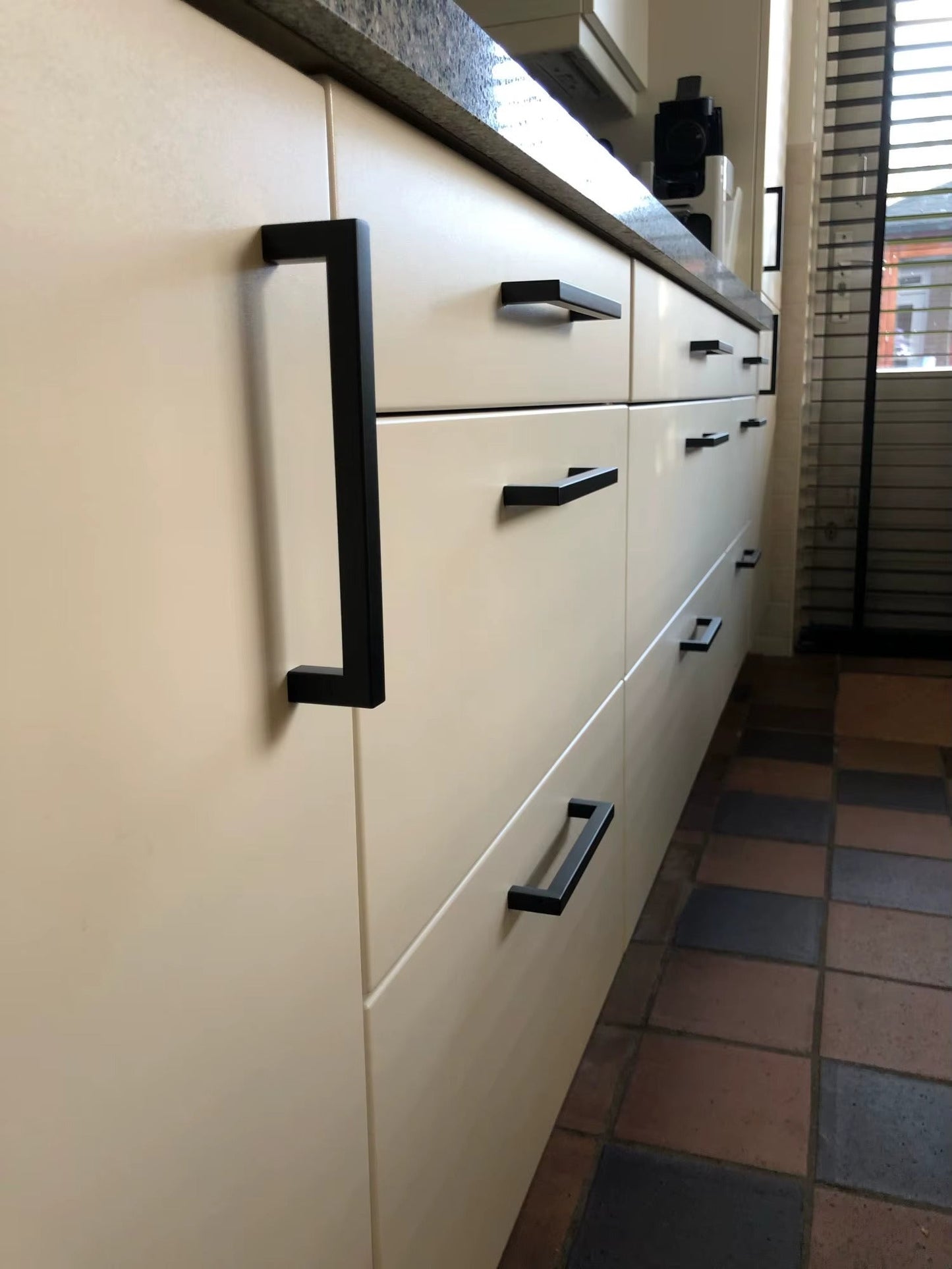 Poignée noire moderne installée sur un meuble