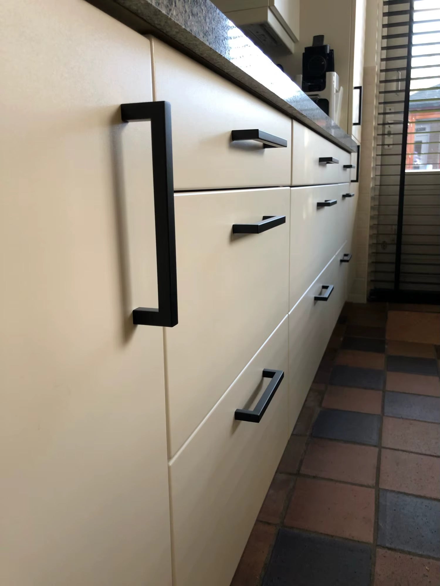 Poignée noire moderne installée sur un meuble