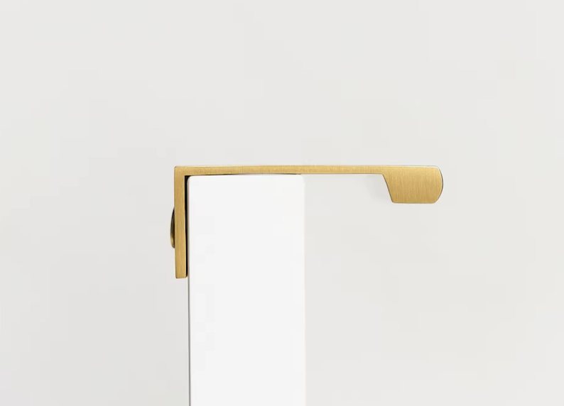 Poignée en laiton doré installée sur un tiroir en bois