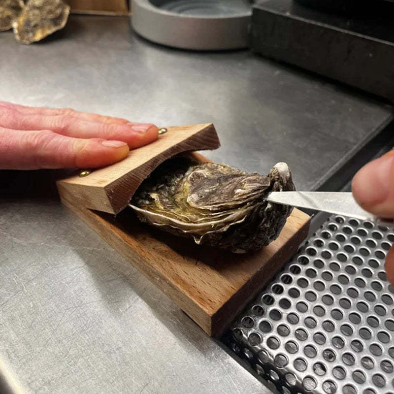 Pince à huître posée sur une surface en bois