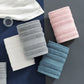 Quatre serviettes en coton doux empilées sur une table