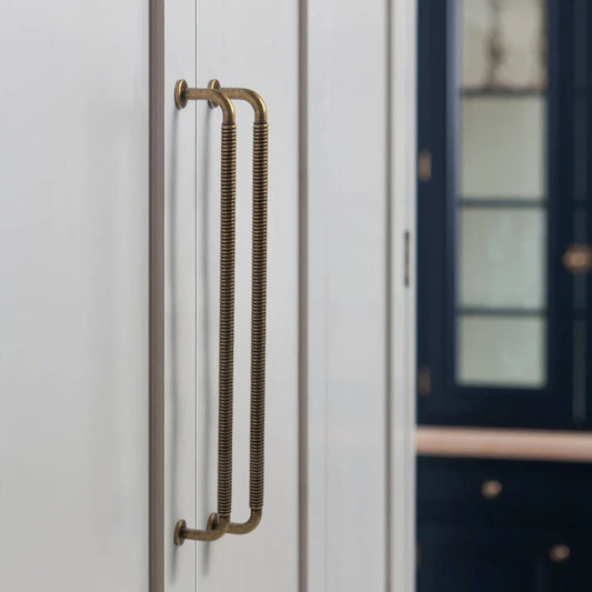 Poignée dorée en aluminium installée sur une armoire