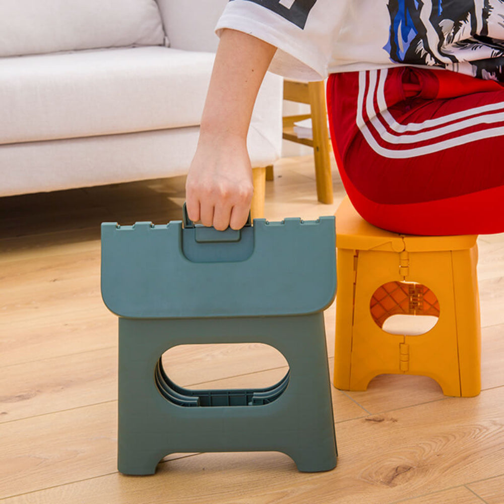 Tabouret pliant utilisé par un enfant pour atteindre une étagère