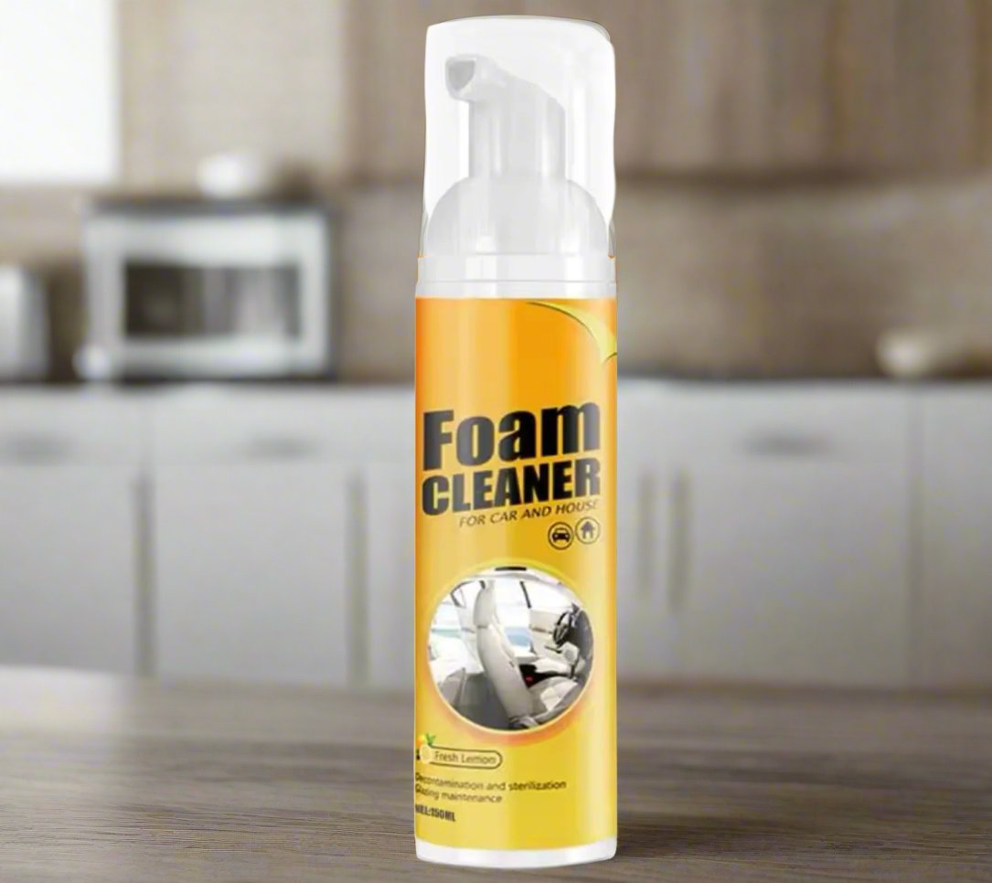 Main appliquant de la mousse nettoyante sur une surface