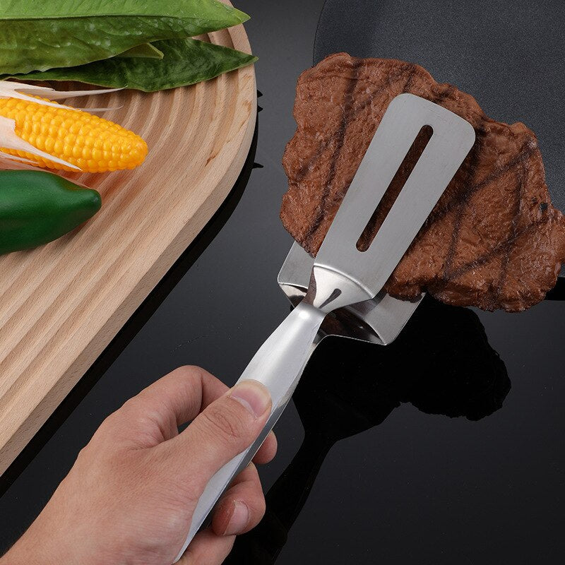 Spatule en acier inoxydable utilisée pour griller de la viande
